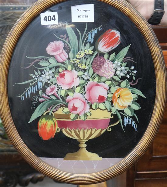 An oval reverse painting on glass of an urn of flowers, 33 x 27cm
